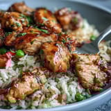 A close-up view shows tender chicken glazed in tangy barbecue sauce mixed into the One-Pan Bold Honey BBQ Chicken Rice.
