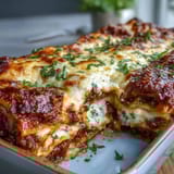 Layers of Worlds Best Lasagna reveal meat sauce, creamy ricotta, and tender pasta sheets in a hearty slice.