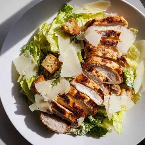 Fresh, vibrant Chicken Caesar Salad with crunchy croutons and a generous Parmesan topping.