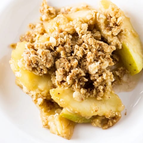 A close-up of a freshly baked Apple Crumble, showing the caramelized apples beneath a sweet crumble.