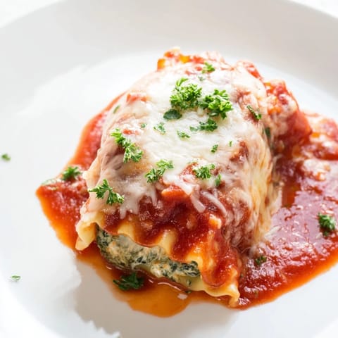 Close-up of Chicken and Spinach Lasagna Rolls on a plate, revealing creamy ricotta filling with tender chicken and spinach inside.  