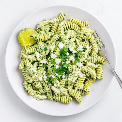 A serving of Cilantro Lime Chicken Pasta garnished with extra cilantro leaves, showcasing tender shredded chicken mixed into the bright, tangy yogurt dressing.