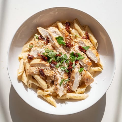 Honey Chipotle Chicken Pasta served steaming hot, garnished with fresh cilantro and grated Parmesan on a rustic plate.