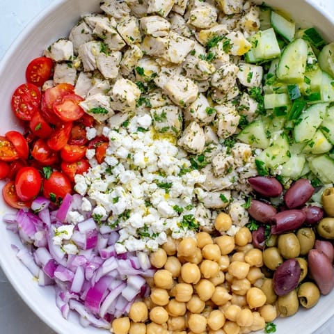 A close-up of Mediterranean Chickpea Chicken Salad showing crisp vegetables, crumbled feta, and briny olives, served on a plate as a protein-packed lunch.  