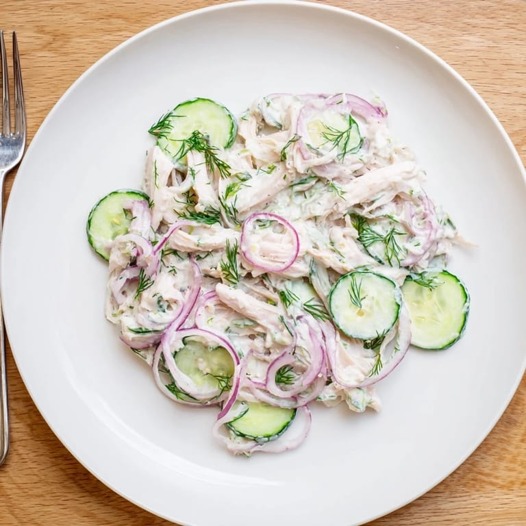 Tender shredded chicken and crisp cucumber slices tossed in a creamy dill yogurt dressing, perfect for a light summer meal.