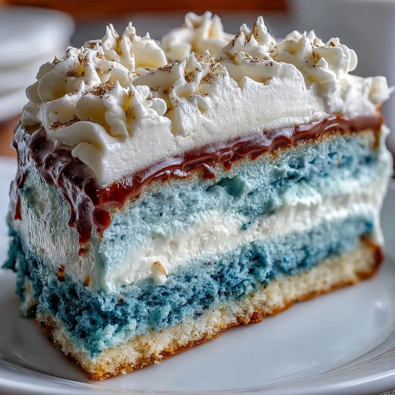 Graduation celebration cake featuring striking ombre blue layers, smooth vanilla frosting, and shimmering gold leaf decoration for a festive milestone dessert.