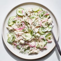 A bowl of creamy cucumber chicken salad, topped with fresh dill and green onions, served as a refreshing high-protein lunch.