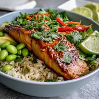 Vibrant Soy Ginger Salmon Bowl with glazed salmon, steamed rice, and crisp vegetables topped with avocado.